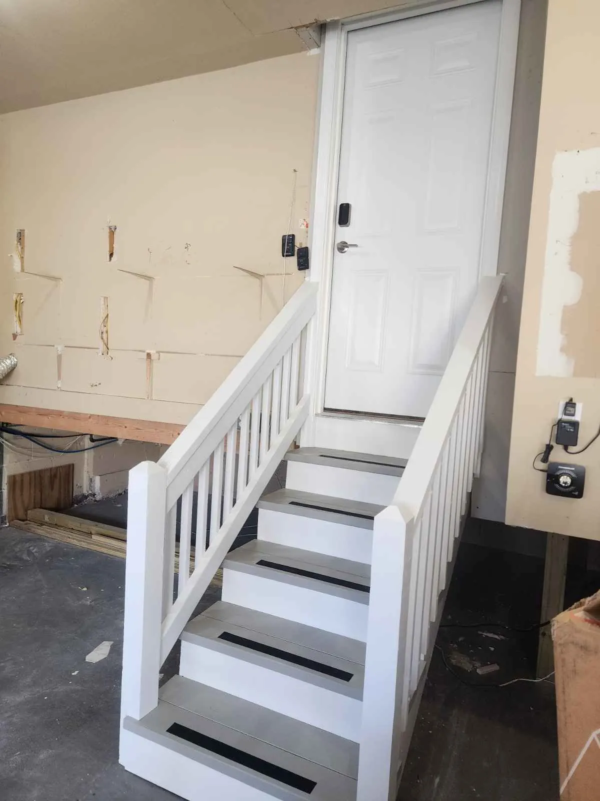 After: basement stairs painted white with black treads and new railing