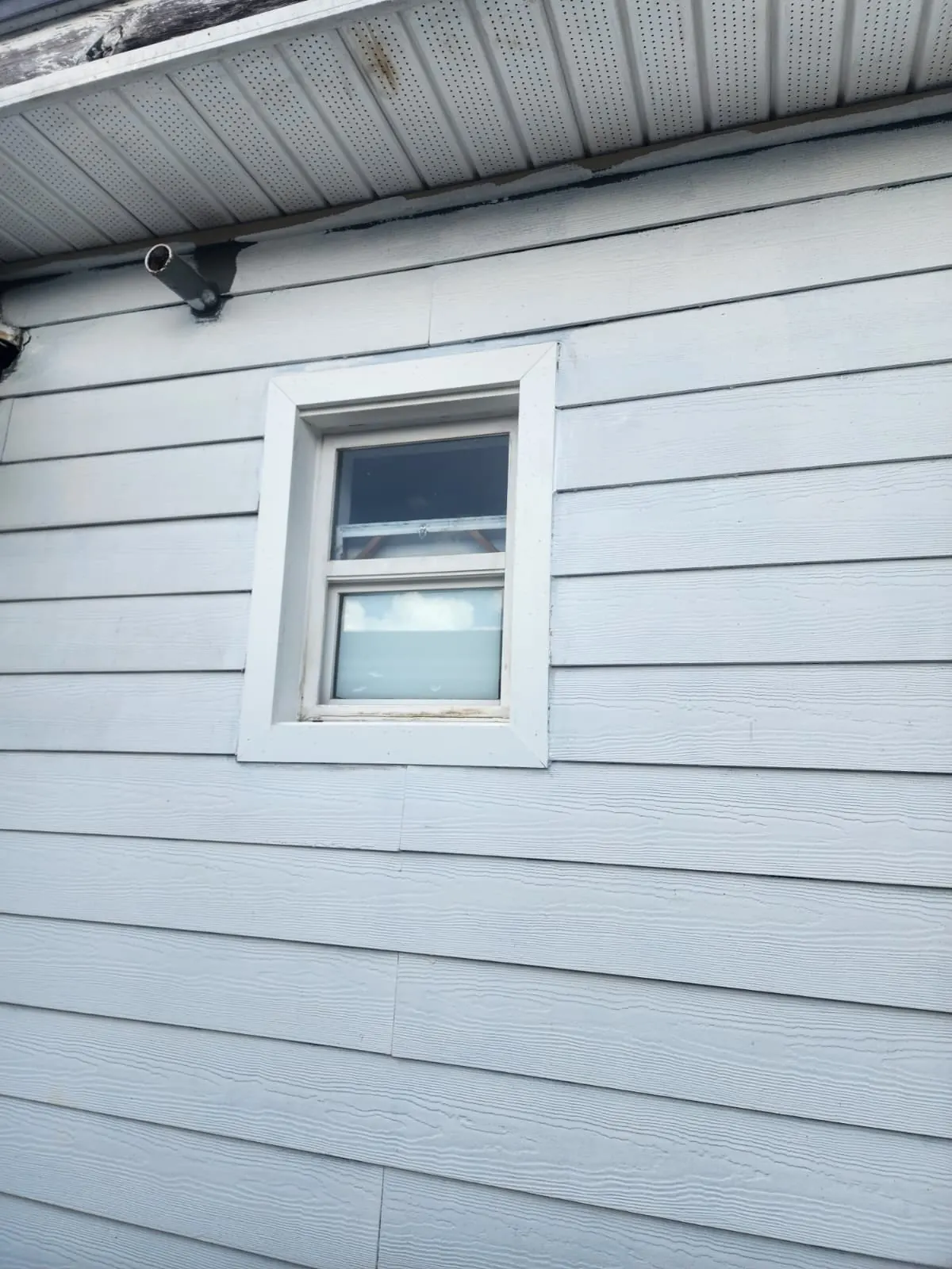 After: window trimmed and siding repaired and painted
