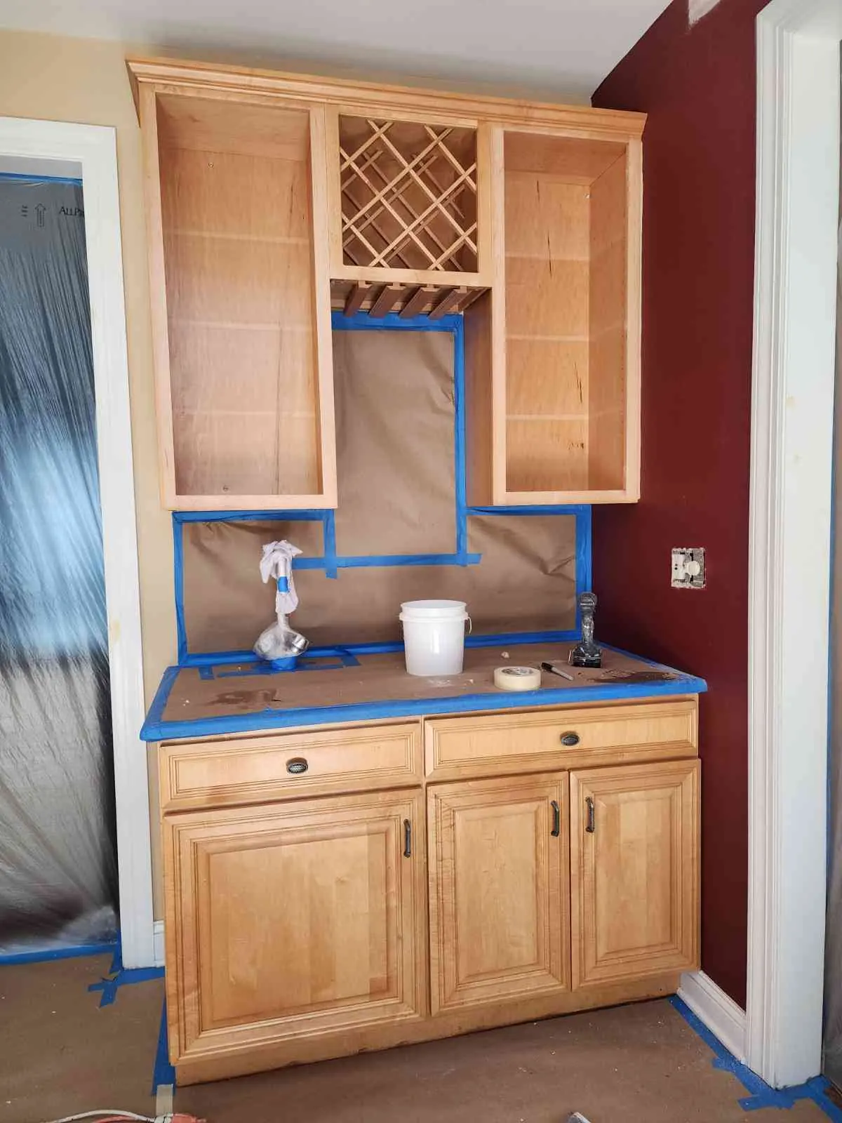 Before: original natural wood bar cabinets taped for refinishing