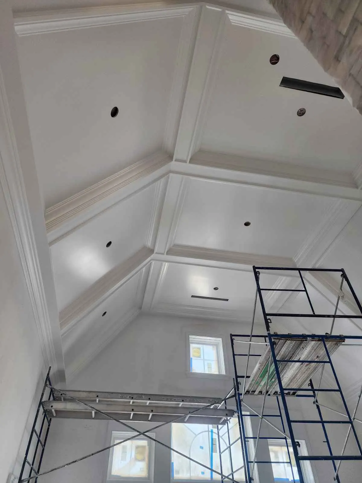 Coffered ceiling painted white, with scaffolding in place